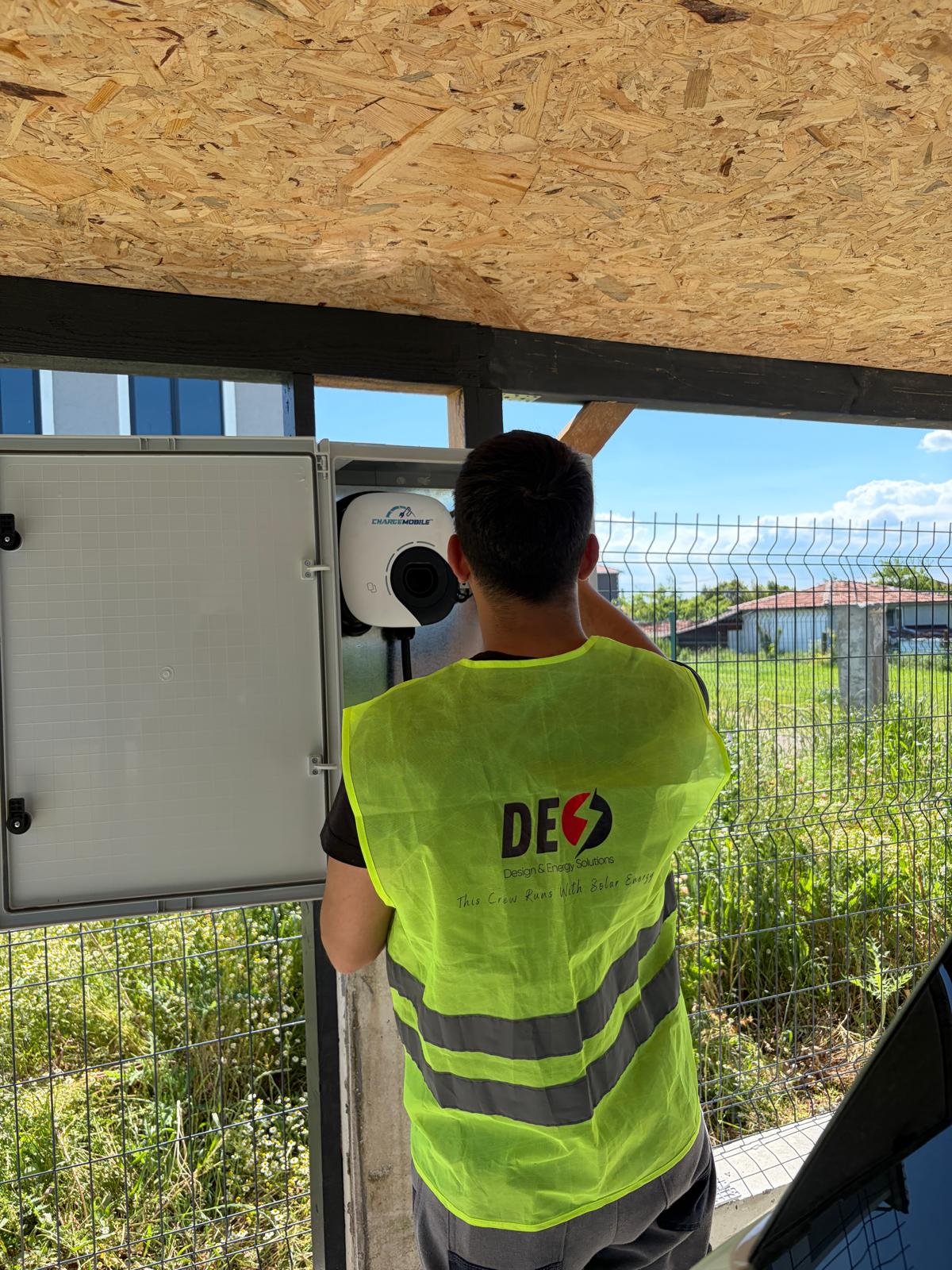 DES Enerji ekibinden bir teknisyen elektrikli araç şarj cihazının kurulumu üzerinde çalışıyor